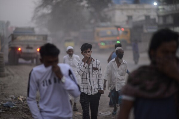People cover their faces to protect themselves from the pollution, in Dhaka, Bangladesh, on Feb. 8, 2025. (AP Photo/Mahmud Hossain Opu)