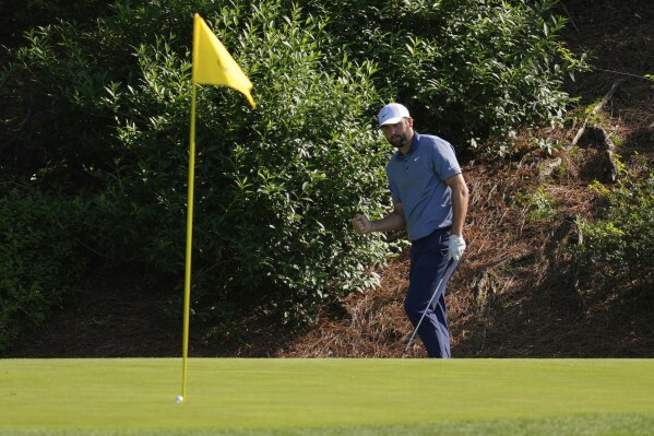 Scottie Scheffler celebrates after chipping in for birdie on the 12th hole during the second round at the Masters golf tournament, Friday, April 11, 2025, in Augusta, Ga. (AP Photo/Ashley Landis)