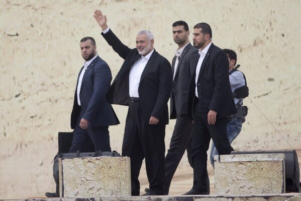 
              FILE - In this Dec. 16, 2018 file photo, Hamas leader Ismail Haniyeh, waves during a rally marking the 31st anniversary of the founding of Hamas, in Gaza city. Haniyeh said Monday, March 25, 2019, that his group will respond if Israel retaliates too forcefully to an overnight rocket strike. Haniyeh's statement came as Israel began striking targets in the Gaza Strip in response to the early morning rocket attack, which wounded seven people in a small town north of Tel Aviv. (AP Photo/Khalil Hamra, File )
            