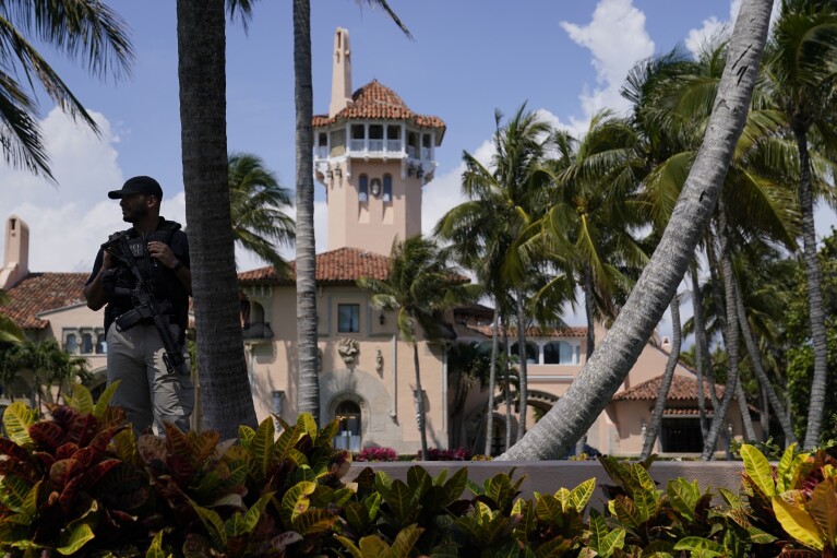 A security guard stands on the perimeter of former President Donald Trump's Mar-a-Lago home, Monday, April 3, 2023, in Palm Beach, Fla., a day before he travels to New York for his arraignment on charges related to hush money payments. (AP Photo/Evan Vucci, File)