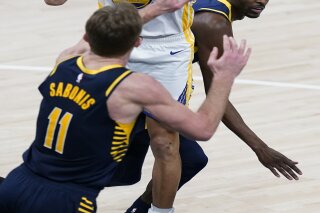 Golden State Warriors' Stephen Curry (30) shoots from between Indiana Pacers' Justin Holiday, right, and Domantas Sabonis during the second half of an NBA basketball game Wednesday, Feb. 24, 2021, in Indianapolis. (AP Photo/Darron Cummings)