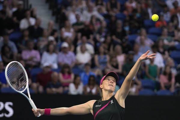 Iga Swiatek z Polska podává Lindě Noskové z České republiky během zápasu třetího kola na tenisovém turnaji Australian Open v Melbourne Park, Melbourne, Austrálie, v sobotu 20. ledna 2024. (AP Photo/Andy Wong)