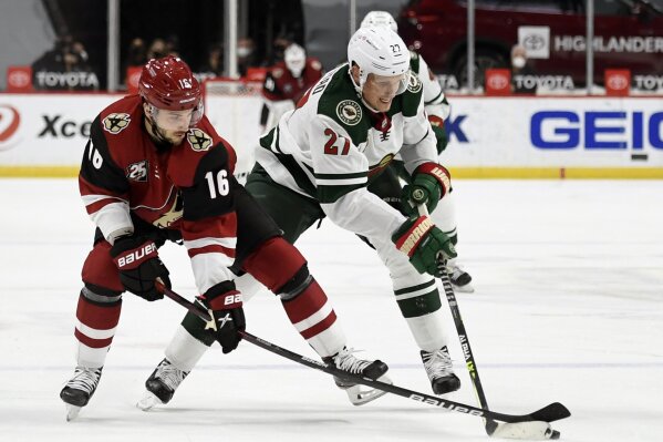 Arizona Coyotes' Derick Brassard (16) and Minnesota Wild's Nick Bjugstad (27) battle for the puck during the second period of an NHL hockey game Tuesday, March 16, 2021, in St. Paul, Minn. (AP Photo/Hannah Foslien)