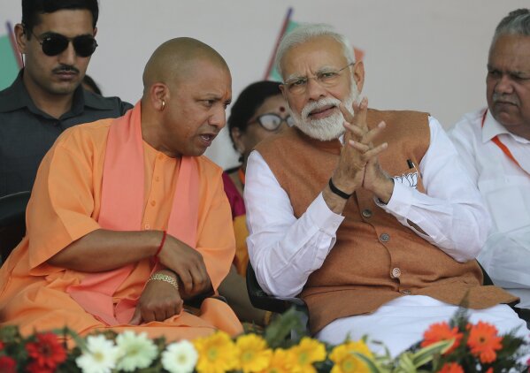 FILE- In this March 28, 2019, file photo, Indian Prime Minister Narendra Modi, right, speaks with Chief Minister of Uttar Pradesh state Yogi Adityanath during an election campaign rally in Meerut, India. India’s ruling Hindu nationalist party has approved legislation in Uttar Pradesh, the country’s most populous state, that lays out a prison term of up to 10 years for anyone found guilty of using marriage to force someone to change religion. The decree was passed Tuesday and follows a campaign by Modi’s Hindu-nationalist Bharatiya Janata Party against interfaith marriages. The party describes such marriages as “love jihad,” an unproven conspiracy theory used by its leaders and Hindu hard-line groups to accuse Muslim men of converting Hindu women by marriage. (AP Photo/Altaf Qadri, File)