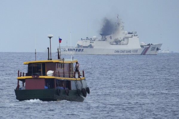 A Philippine supply boat manuevers as a Chinese coast guard tries to block it's way as it heads towards Second Thomas Shoal, locally known as Ayungin Shoal, at the disputed South China Sea on Tuesday, Aug. 22, 2023. As a U.S. Navy plane circled overhead, two Philippine navy-manned boats manage to breach through a Chinese coast guard blockade in a dangerous confrontation in the disputed South China Sea and succeeded in delivering food and other supplies to Filipino forces guarding a contested shoal on board BRP Sierra Madre. (AP Photo/Aaron Favila)