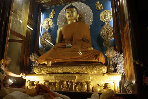FILE - A priest makes an offering at a statue of Buddha in the Mahabodhi temple at Bodh Gaya, India, on Wednesday, Jan. 6, 2010. Bodh Gaya is the town where Prince Siddhartha Gautama attained enlightenment after intense meditation and became the Buddha, about 2,600 years ago. (APPhoto/Rajesh Kumar Singh, File)