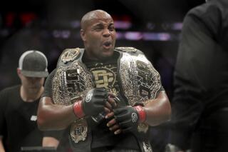 FILE - Daniel Cormier reacts after defeating Derrick Lewis by submission in the second round of a heavyweight mixed martial arts bout at UFC 230, early Sunday, Nov. 4, 2018, at Madison Square Garden in New York. Cormier insisted he retired from MMA competition. So what was the two-time UFC heavyweight champion doing again Saturday night inside a cage? Cormier was the guest referee at a WWE event and he told The Associated Press after the card he's thinking of following in the path of Ronda Rousey and Brock Lesnar and making the jump to the squared circle. (AP Photo/Julio Cortez, File)