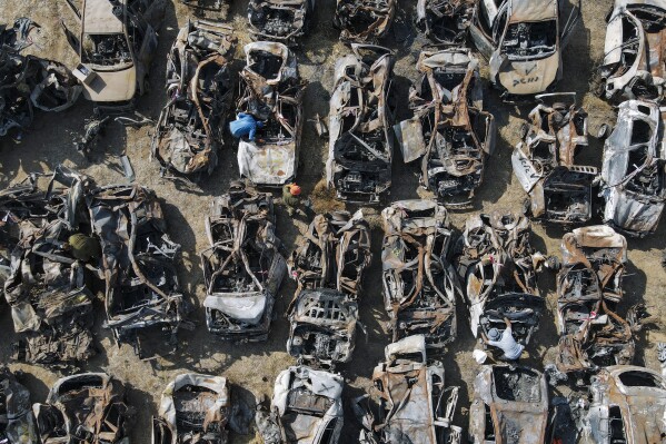Israeli security forces inspect charred vehicles burned in the bloody Oct. 7 cross-border attack by Hamas militants, outside the town of Netivot, southern Israel. The vehicles were collected and placed in an area near the Gaza border after the attack. (AP Photo/Ariel Schalit)