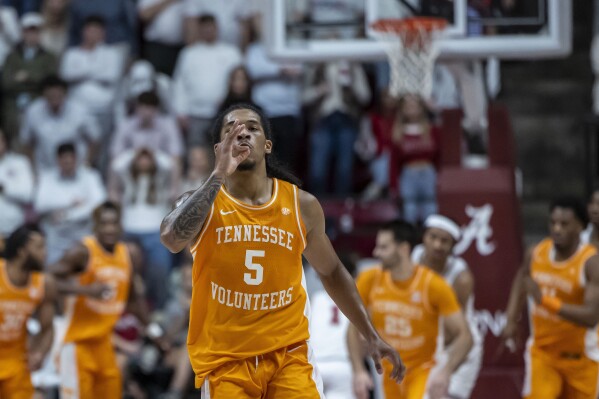 Tennessee guard Zakai Zeigler (5) mimes smoking a cigar, a tradition of the winner of the Alabama-Tennessee series, after he shot a three-point basket during the second half of an NCAA college basketball game against Alabama, Saturday, March 2, 2024, in Tuscaloosa, Ala. (AP Photo/Vasha Hunt)