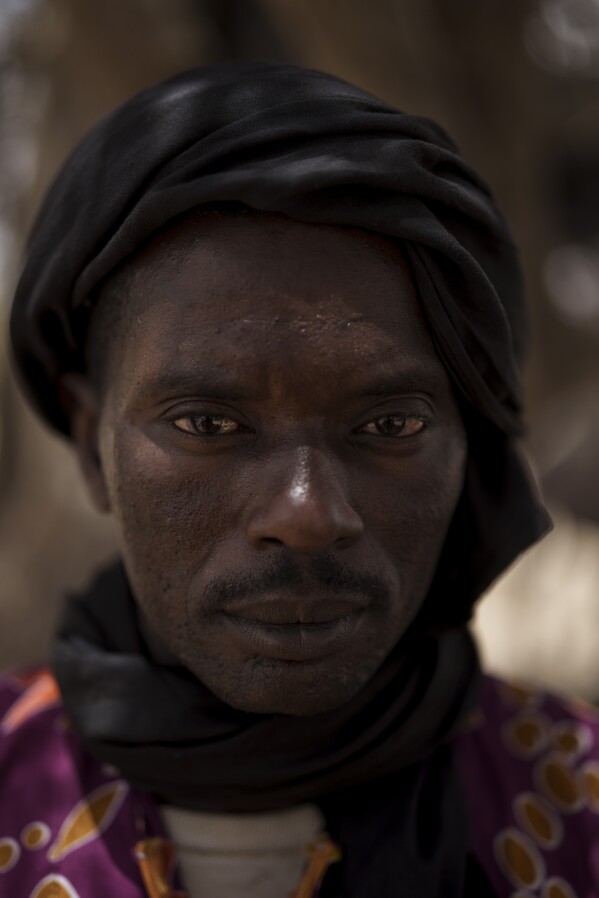 Kebe Pathe Ba stands for a portrait at a local market near a water station known as Bem Bem, in the Matam region of Senegal, Wednesday, April. 19, 2023. The 41-year-old herder says, "It's only the raising of livestock that we like. ... That's all we know how to do, even if we were in France or the USA. ... Our whole life is governed by this (being a herder)." (AP Photo/Leo Correa)