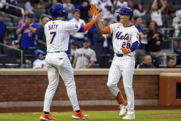 New York Mets' Jared Young (29) high fives Brett Baty (7) after his first home run of the season during the first inning against the Chicago White Sox, Tuesday, May 27, 2025, in New York. Baty scored on Young's home run. (AP Photo/Angelina Katsanis)