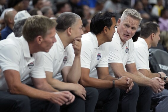 United States head coach Steve Kerr, fourth from left, speaks with assistant coach Erik Spoelstra, third from left, during the first half of an exhibition basketball game against Puerto Rico, Monday, Aug. 7, 2023, in Las Vegas. (AP Photo/John Locher)