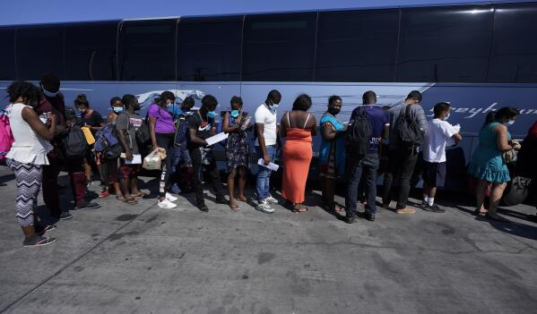 Migrants, many from Haiti, board a bus after they were processed and released after spending time at a makeshift camp near the International Bridge, Monday, Sept. 20, 2021, in Del Rio, Texas. The U.S. is flying Haitians camped at Texas border town back to their homeland and trying to block others from crossing the border from Mexico. (AP Photo/Eric Gay)