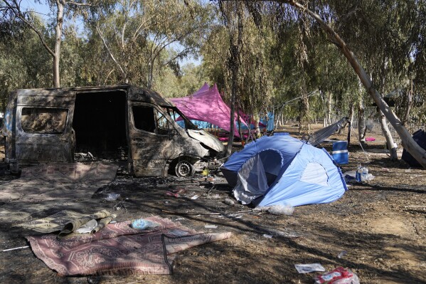 Tents, debris and a burned out van are scattered about the site of a music festival near the border with the Gaza Strip in southern Israel on Thursday, Oct. 12, 2023. At least 260 Israeli festival-goers were killed during the attack by Hamas gunmen on Saturday, Oct. 7. (AP Photo/Ohad Zwigenberg)