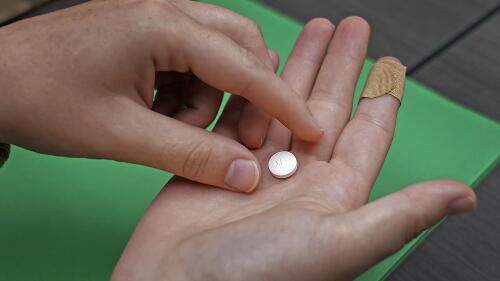 FILE - A patient prepares to take the first of two combination pills, mifepristone, for a medication abortion during a visit to a clinic in Kansas City, Kan., on Oct. 12, 2022. Abortion providers sued Kansas on Tuesday, June 6, 2023, challenging a new law requiring them to tell patients that an abortion medication can be stopped but also existing restrictions that include a decades-old requirement that patients wait 24 hours to terminate their pregnancies. (AP Photo/Charlie Riedel, File)