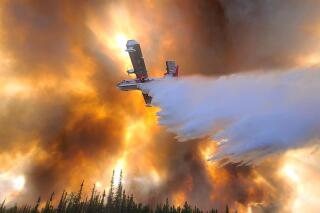 In this photo provided by Eric Kiehn, Northwest Incident Management Team 10, Alaska Division of Forestry, a fixed-wing aircraft drops water on the Clear Fire near Anderson, Alaska, July 6, 2022. One home has been destroyed by the wildfire burning in Alaska’s interior, while a majority of people under evacuation orders are sheltering in place. (Eric Kiehn, Northwest Incident Management Team 10, Alaska Division of Forestry via AP)
