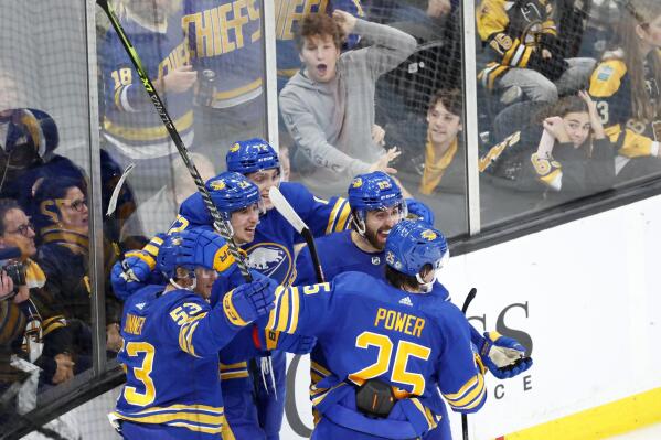 Buffalo Sabres players celebrate with Dylan Cozens (24) after Cozens scored the game-tying goal late in the third period of an NHL hockey game against the Boston Bruins, Saturday, Dec. 31, 2022, in Boston. (AP Photo/Mary Schwalm)