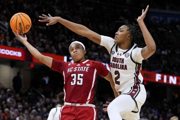 South Carolina forward Ashlyn Watkins (2) tries to block a shot by North Carolina State guard Zoe Brooks (35) during the second half of a Final Four college basketball game in the women's NCAA Tournament, Friday, April 5, 2024, in Cleveland. (AP Photo/Morry Gash)