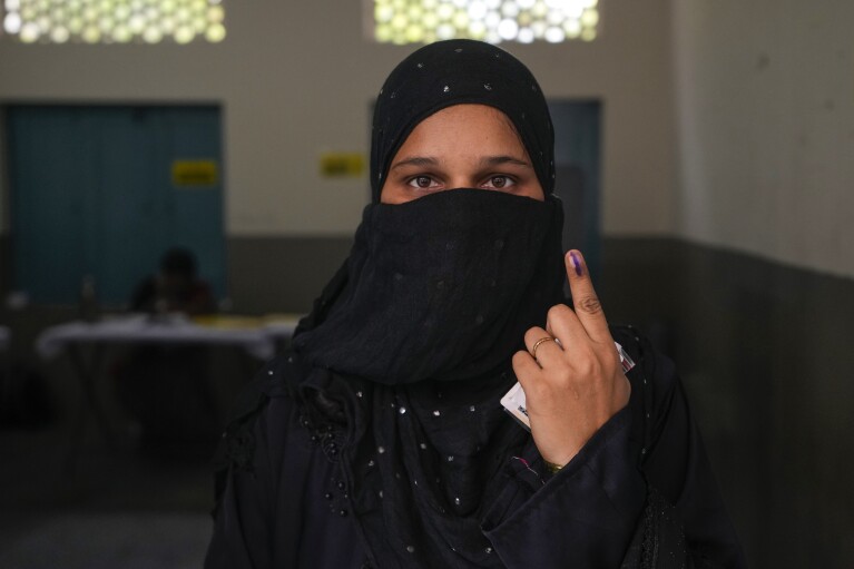 Una mujer muestra la marca de tinta indeleble en su dedo índice después de emitir su voto en un colegio electoral durante la cuarta fase de las elecciones generales en Hyderabad, India, el lunes 13 de mayo de 2024. (Foto AP/Mahesh Kumar A.)