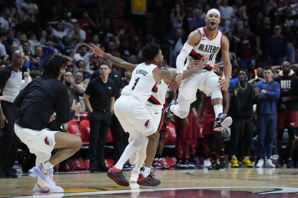 Portland Trail Blazers players mob guard Josh Hart (11) after he made a three-point shot at the buzzer to win an NBA basketball game against the Miami Heat, 110-107, Monday, Nov. 7, 2022, in Miami. (AP Photo/Wilfredo Lee)