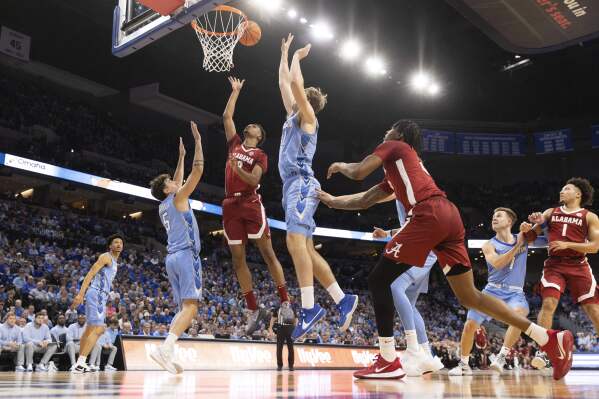 Alabama's Rylan Griffen (3) shoots against Creighton's Francisco Farabello (5) and Isaac Traudt (41) during the first half of an NCAA college basketball game Saturday, Dec. 16, 2023, in Omaha, Neb. (AP Photo/Rebecca S. Gratz)