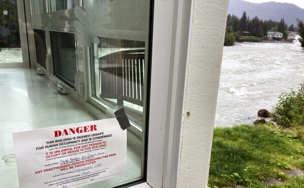 A sign marks a house along the Mendenhall River in Juneau, Alaska, condemned following a glacial dam outburst that resulted in weekend flooding along the river. (AP Photo/Becky Bohrer)