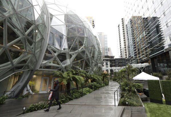 
              In this Nov. 9, 2018 file photo, a pedestrian walks near the Amazon Spheres in downtown Seattle.  Many of Amazon’s Seattle-area employees will likely be exempt from new proposed labor protections after a push by the tech giant’s lobbyists to raise the salary threshold at which the rules would kick in. The changes would partially prohibit so-called non-compete clauses, agreements widely used by tech companies and others to prohibit employees from going to work for competitors.(AP Photo/Ted S. Warren, File)
            