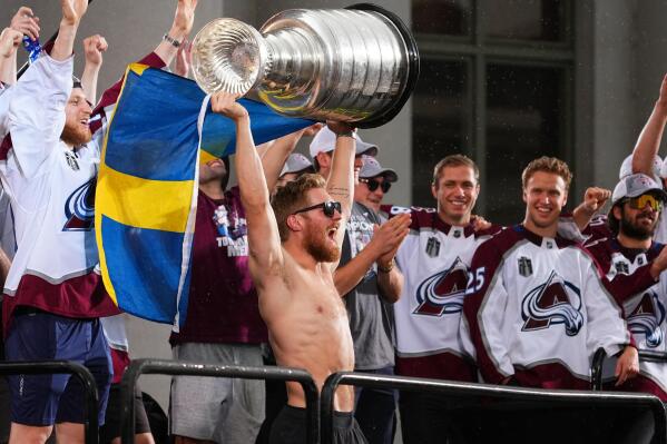 Colorado Avalanche left wing Gabriel Landeskog hoists the Stanley Cup and a flag of Sweden at a rally for the NHL hockey champions Thursday, June 30, 2022, in Denver. (AP Photo/Jack Dempsey)