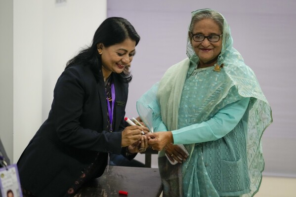A Bangladeshi polling officer puts indelible ink on the finger of Bangladesh Prime Minister Sheikh Hasina after arriving to cast her vote in Dhaka, Bangladesh, Sunday, Jan. 7, 2024. (AP Photo/Altaf Qadri)