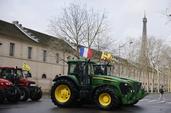 Farmers drive their tractors, Friday, Feb. 23, 2024 in Paris. Angry farmers were back to Paris on their tractors in a new protest demanding more government support and simpler regulations, on the eve of a major agricultural fair in the French capital. (AP Photo/Thomas Padilla)