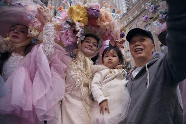 A man takes a selfie with revelers wearing decorated hats and costumes as they participate in the annual Easter Parade and Bonnet Festival in front of St. Patrick's Cathedral on Sunday, April 20, 2025, in New York. (AP Photo/Andres Kudacki)