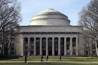 FILE - Students walk past the "Great Dome" atop Building 10 on the Massachusetts Institute of Technology campus, April 3, 2017, in Cambridge, Mass. The Justice Department dropped its case Thursday, Jan. 20, 2022 against MIT professor Gang Chen, charged last year with hiding work he did for the Chinese government, saying it "could no longer meet its burden of proof at trial." Chen was accused last year of concealing ties to Beijing while also collecting U.S. dollars for his nanotechnology research. (AP Photo/Charles Krupa, File)