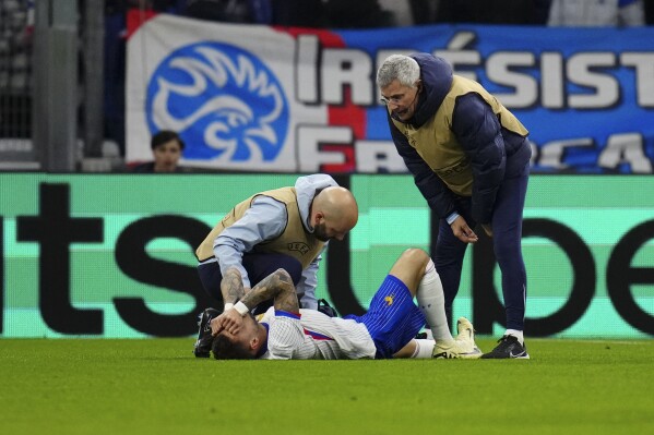 France's Jonathan Clauss receives medical attention during an international friendly soccer match between France and Chile at the Orange Velodrome stadium in Marseille, southern France, Tuesday, March 26, 2024. (AP Photo/Daniel Cole)