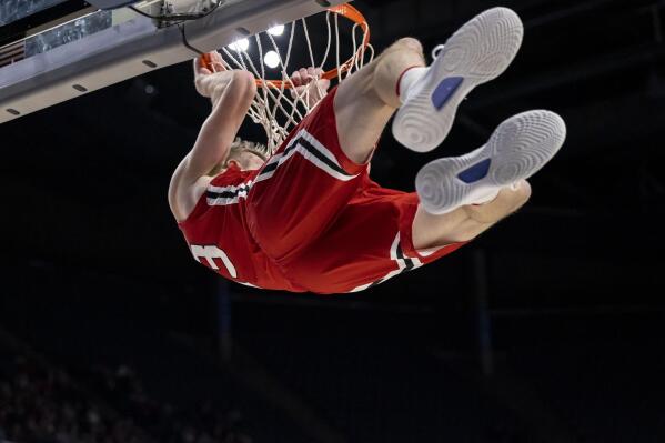 Davidson guard Michael Jones (13) holds on after a dunk against Alabama during the second half of an NCAA college basketball game, Tuesday, Dec. 21, 2021, in Birmingham, Ala. (AP Photo/Vasha Hunt)