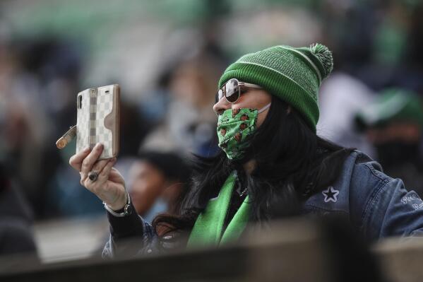 A Marshall fan films the opening kickoff of an NCAA college football game on Saturday, Dec. 5, 2020, in Huntington, W.Va.  (Sholten Singer/The Herald-Dispatch via AP)