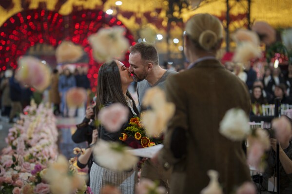 A couple kiss after a mock marriage ceremony dubbed "Married for one day" during a Valentine's Day event in Bucharest, Romania, Tuesday, Feb. 13, 2024. (AP Photo/Vadim Ghirda)