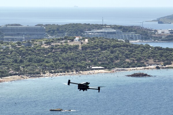 A long-range drone equipped with thermal imaging cameras and a sophisticated early warning system patrols over Kavouri beach and nearby woodland, in southern Athens, Greece, Thursday, Aug. 17, 2023. Greece is plagued by hundreds of wildfires each summer. To protect their area from potentially deadly blazes, a group of residents from a suburb in northern Athens have joined forces to hire a company using long-range drones equipped with thermal imaging cameras and a sophisticated early warning system to catch fires before they can spread. (AP Photo/Thanassis Stavrakis)