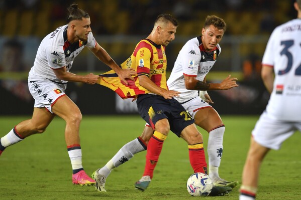 Lecce's Ylber Ramadani, center, fights for the ball during the Serie A soccer match between Lecce and Genoa at the Via del Mare stadium in Lecce, Italy, Friday, Sept. 22, 2023. (Giovanni Evangelista/LaPresse via AP)
