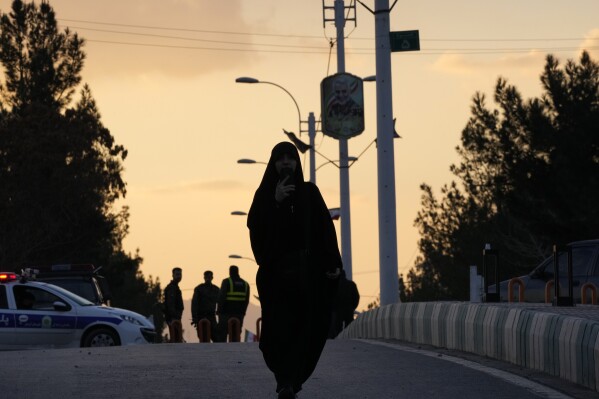 A woman walks toward the grave of the late Iranian Revolutionary Guard Gen. Qassem Soleimani in the city of Kerman, about 510 miles (820 kilometers) southeast of the Iranian capital, Tehran, on Thursday, Jan. 4, 2024.  Investigators believe that suicide bombers may have done this.  An attack commemorating an Iranian general killed in a 2020 US drone strike came as Iran grapples with its biggest mass-casualty attack in decades and the wider Mideast remains on edge, state media reported on Thursday.  (AP Photo/Vahid Salemi)
