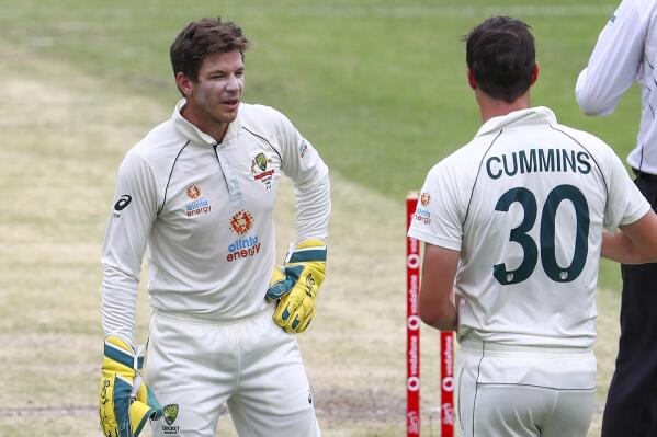 FILE - Australia's Tim Paine, left, talks with bowler Pat Cummins during play on day three of the fourth cricket test between India and Australia at the Gabba, Brisbane, Australia, on Jan. 17, 2021. Paine made a return to first-class cricket, Thursday, Oct. 6, 2022, for the first time in 18 months since he quit as test skipper after after a scandal involving explicit text messages he sent to a co-worker in 2017. (AP Photo/Tertius Pickard, File)