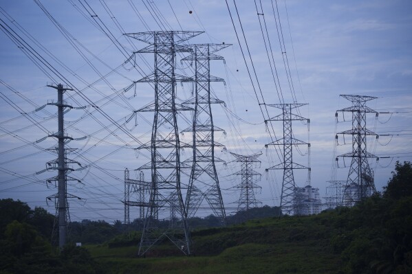 Power lines are seen near a power plant near Dengkil on the outskirt of Kuala Lumpur, Malaysia, on Sept. 11, 2023. The urgency for Southeast Asian nations to switch to clean energy to combat climate change is reinvigorating a 20-year-old plan for the region to share power.(AP Photo/Vincent Thian)