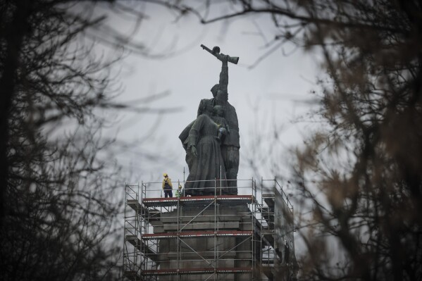 Workers prepare to dismantle the figures of the monument of the Soviet Army in Sofia, Tuesday, Dec. 12, 2023. Following years of heated debates, authorities in Bulgaria began to dismantle a monument of the Soviet army that has dominated the skyline of the capital city of Sofia, and has been considered widely as a symbol of Russia's influence in the Balkan country. (AP Photo/Valentina Petrova)