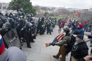 FILE - Rioters face off with police at the U.S. Capitol on Jan. 6, 2021, in Washington. A growing number of Capitol riot defendants are pushing to get their trials moved out of Washington. They claim they can't get a fair trial before unbiased jurors in the District of Columbia. (AP Photo/Jose Luis Magana, File)