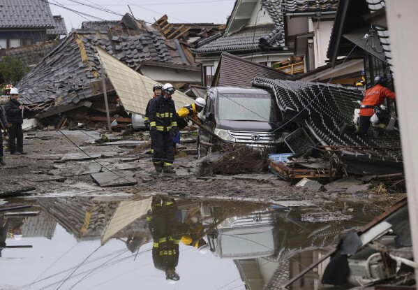 Firefighters search collapsed houses hit by earthquakes in Suzu, Ishikawa prefecture, Japan Wednesday, Jan. 3, 2024. (Kyodo News via AP)
