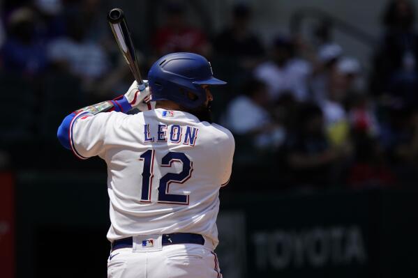 Texas Rangers' Sandy Leon (12) stands at bat during a baseball game against the Arizona Diamondbacks in Arlington, Texas, Wednesday, May 3, 2023. Veteran big league catcher Sandy León changed his uniform to No. 12 this season with the Texas Rangers to remind himself of the worst day of his life. (AP Photo/LM Otero)