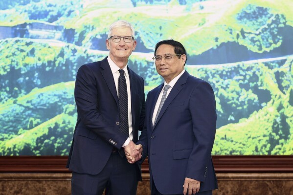 Apple CEO Tim Cook, left, shakes hands with Vietnamese Prime Minister Pham Minh Chinh in Hanoi, Vietnam on Tuesday, April 16, 2024. The tech giant CEO is on a visit to Vietnam to promote cooperation and boost investment in the Southeast Asian nation. (Duong Van Giang/VNA via AP)