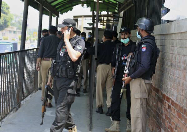FILE - Police officers gather at an entry gate of district court following the killing of Tahir Shamim Ahmad, who was in court accused of insulting Islam, in Peshawar, Pakistan, Wednesday, July 29, 2020.   Tahir Shamim Ahmad was a U.S. citizen, according to a U.S. State Department statement.  (AP Photo/Muhammad Sajjad)