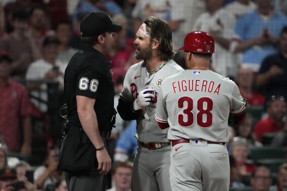 Philadelphia Phillies' Bryce Harper argues with home plate umpire Alex Tosi, left, while being held back by Phillies first base coach Paco Figueroa (38) after Harper was thrown out of the game by Tosi during the third inning of a baseball game against the St. Louis Cardinals Friday, Sept. 15, 2023, in St. Louis. (AP Photo/Jeff Roberson)