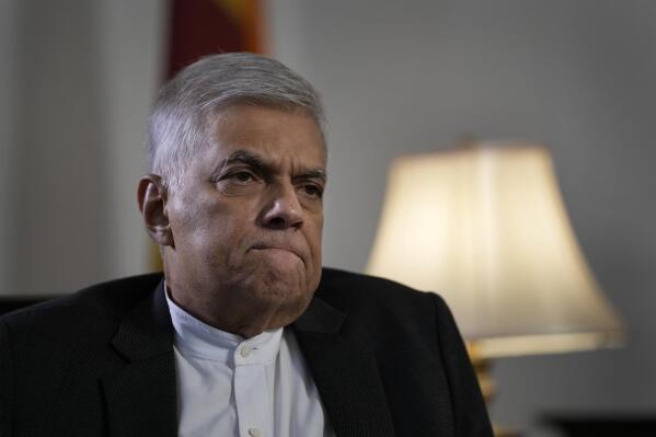 FILE- Sri Lanka's prime minister Ranil Wickremesinghe gestures during an interview with The Associated Press in Colombo, Sri Lanka, June 11, 2022. Sri Lanka's president, who fled on a military jet after angry protesters seized his home and office, has appointed Wickremesinghe as acting president while he is overseas. (AP Photo/Eranga Jayawardena, File)