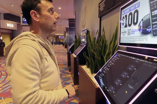 Matt Smircich, of Hamburg, N.J., makes sports bets at the Hard Rock casino in Atlantic City, N.J., Friday, Feb. 2, 2024. On Tuesday, Feb. 6, 2024, the American Gaming Association estimated that a record 68 million Americans would wager a total of $23.1 billion on this year's Super Bowl, legally or otherwise. (AP Photo/Wayne Parry)